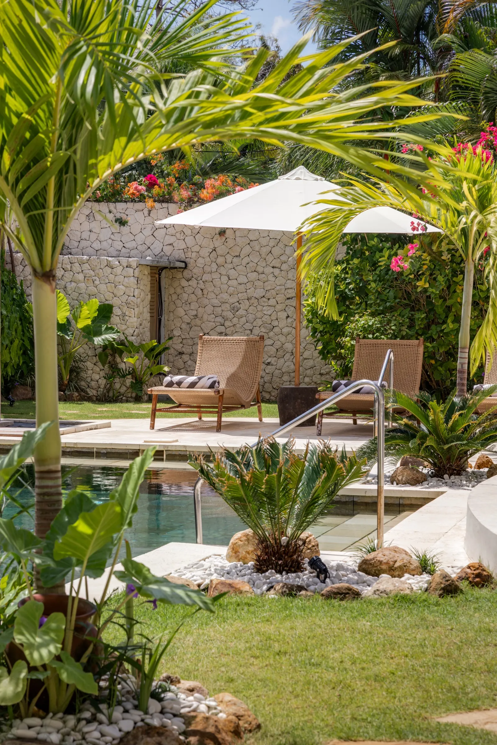 Sun loungers beside the pool at Madu Bungalow Bingin, midday
